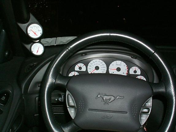 Ford Mustang steering wheel and white-face gauge cluster with two A-pillar gauges