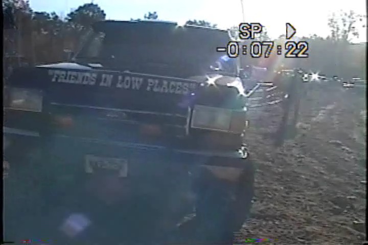 1989 Ford Bronco with "FRIENDS IN LOW PLACES" text on hood, driving off-road