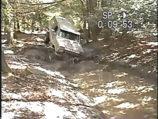 1989 Ford Bronco - This 1980s Ford Bronco tackles a challenging muddy terrain, demonstrating its off-road capabilities.