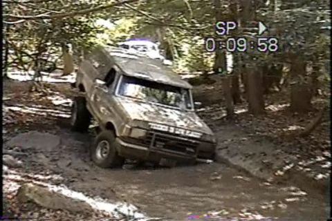 1989 Ford Bronco - This 1989 Ford Bronco is shown navigating a challenging muddy trail in a wooded area.
