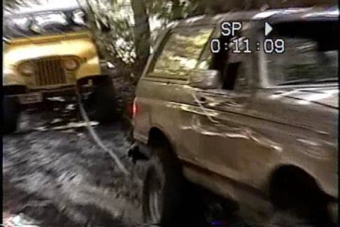 1989 Ford Bronco - A 1989 Ford Bronco is parked next to a yellow Jeep in a wooded area, with a timestamp overlay on the video.
