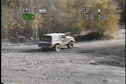 1989 Ford Bronco - 1989 Ford Bronco navigates a dirt path, with an ATV visible nearby.