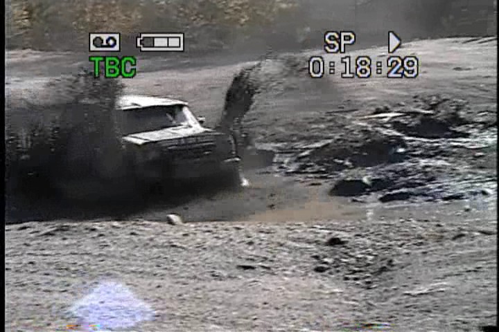 SUV driving through mud, kicking up a lot of spray