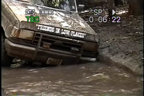 1989 Ford Bronco - This 1989 Ford Bronco is stuck deep in the mud, with a humorous decal on its hood.