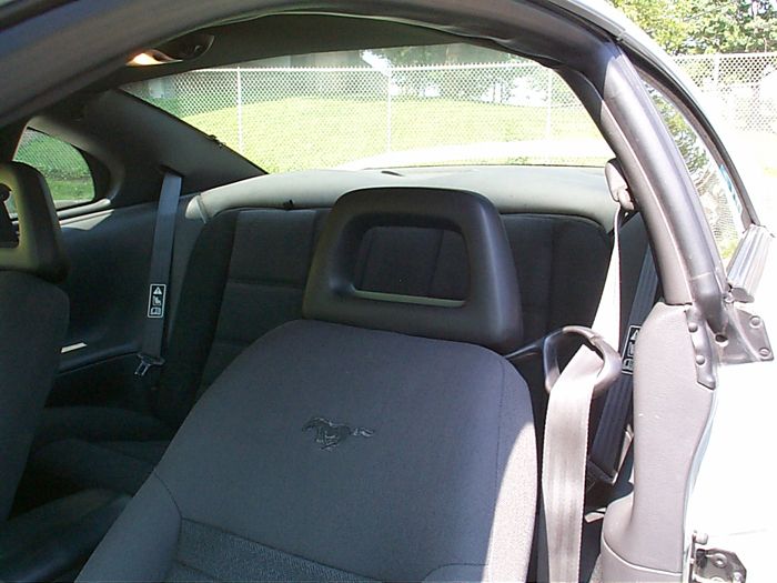 Gray cloth Mustang front seat with embroidered pony logo, seen through open passenger door