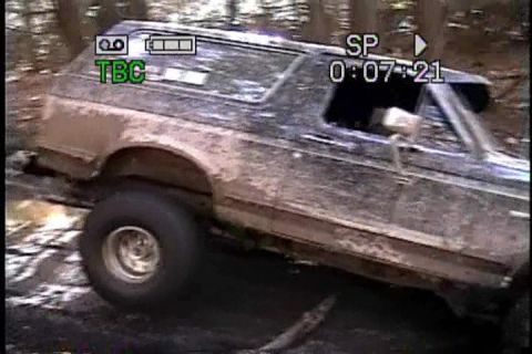 1989 Ford Bronco - This muddy SUV is captured in a 3/4 front view while navigating rough terrain.