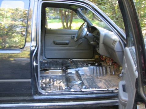 1994 Toyota Tacoma - Interior view of a 1994 Toyota Tacoma with the driver's side door open and carpet removed.