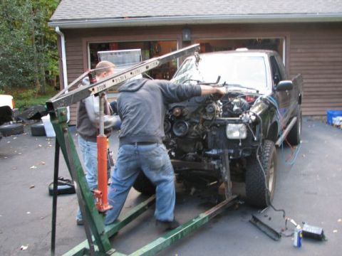1994 Toyota Tacoma - Mechanics use an engine hoist to remove the engine from a 1994 Toyota Tacoma.