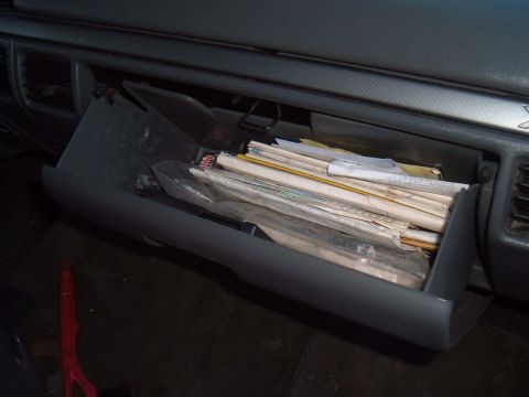 1971 Ford Ranchero - The interior of a vehicle shows an open glove compartment stuffed with documents.