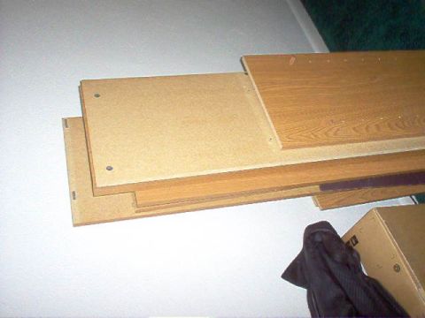 1994 Ford Probe - A stack of wooden boards, some with a wood grain finish, are piled up against a wall.