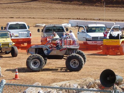 1986 Ford Bronco - Several vehicles, including an off-road buggy, are gathered at an outdoor event.