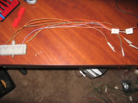 1991 Ford Bronco - A complex wiring harness with labeled wires is laid out on a desk, suggesting automotive repair or modification.
