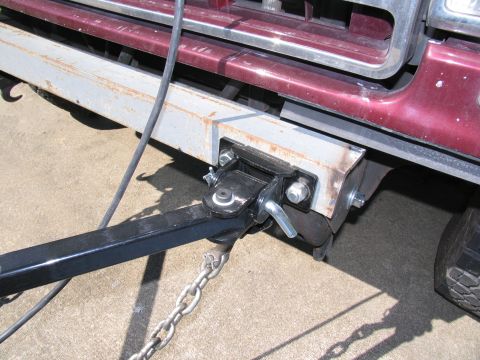 1988 Ford C-350 (Centurion Conversions) - Trailer hitch assembly and safety chains attached to the frame of a vehicle.