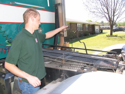 1988 Ford C-350 (Centurion Conversions) - Man points to the exhaust stack of a large truck, with a house and yard in the background.