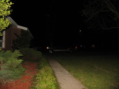 1988 Ford C-350 (Centurion Conversions) - A dark pickup truck is parked in a driveway at night, illuminated by nearby lights.
