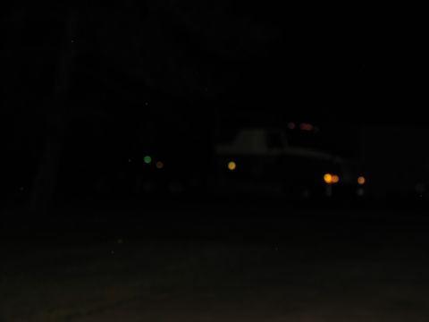 1988 Ford C-350 (Centurion Conversions) - A blurry truck is visible at night, with its headlights illuminated.