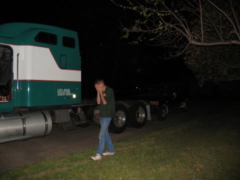 1988 Ford C-350 (Centurion Conversions) - A person stands next to a semi-truck cab and chassis at night, appearing distressed.