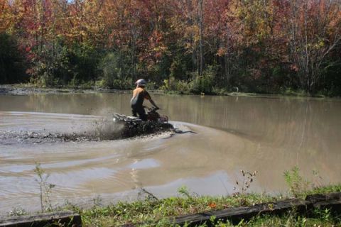 1987 Ford Bronco - ATV rider navigates a muddy trail during autumn.