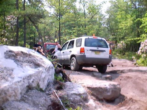 2001 Ford Escape - White 2001 Ford Escape navigates a challenging off-road course with a red vehicle in the background.