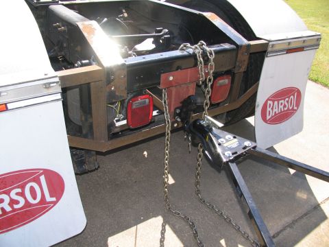 1988 Ford C-350 (Centurion Conversions) - The rear of a truck chassis is shown, equipped with a tow hitch and safety chains. The mud flaps feature the 'BARSOL' logo.