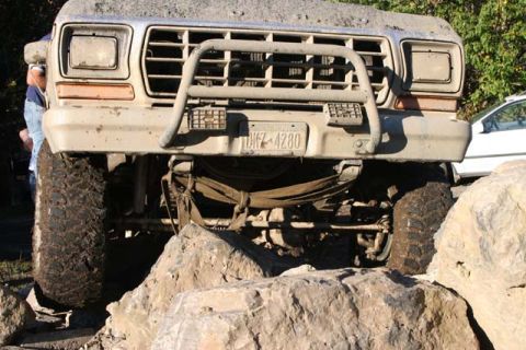 1987 Ford Bronco - This heavily modified 1980s Ford Bronco is navigating a challenging rocky terrain.