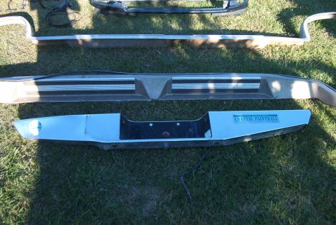 1988 Ford E250 - Multiple vehicle bumpers are displayed on a grassy surface, with one a sticker for "COASTAL PAINTBALL".