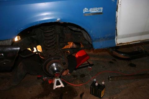 1987 Ford Bronco - Mechanic working on the front suspension of a 1987 Ford Bronco.
