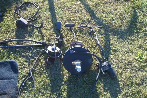 1988 Ford E250 - Assorted vehicle parts, including a brake booster and steering components, are displayed on a grassy surface.