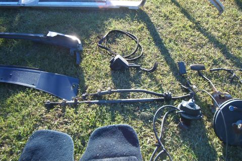 1988 Ford E250 - Various automotive parts are displayed on a grassy surface, suggesting a sale or dismantling.