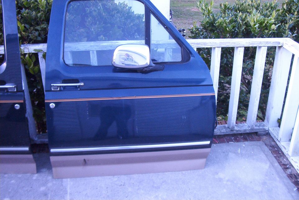 Dark blue van doors with tan lower trim and chrome mirror