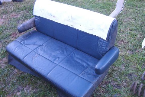 1988 Ford E250 - This appears to be a car seat, possibly from a van or truck, sitting outside on the grass.