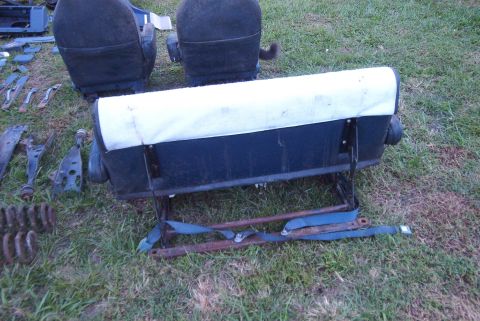 1988 Ford E250 - Vehicle seats and various metal parts are displayed on a grassy area.