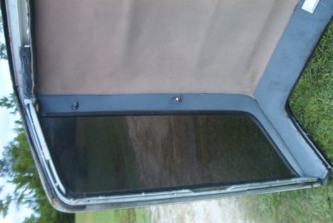 1988 Ford E250 - Close-up view of van interior trim panel and window, showing the headliner and side panel.