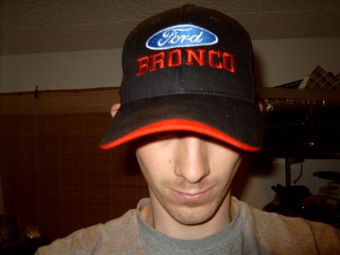 1989 Ford Bronco - A person wears a hat with Ford Bronco branding, not a vehicle itself.
