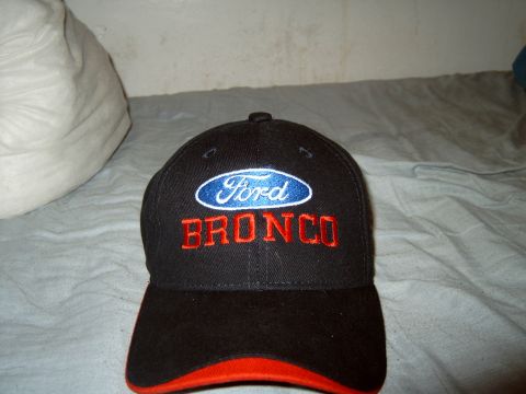 1989 Ford Bronco - A black baseball cap with Ford and Bronco branding is shown against a textured background.