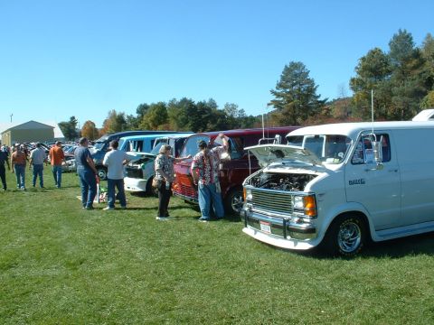 1978 Ford Mustang II - A gathering of vans on display at an outdoor event, with hoods open on some vehicles.
