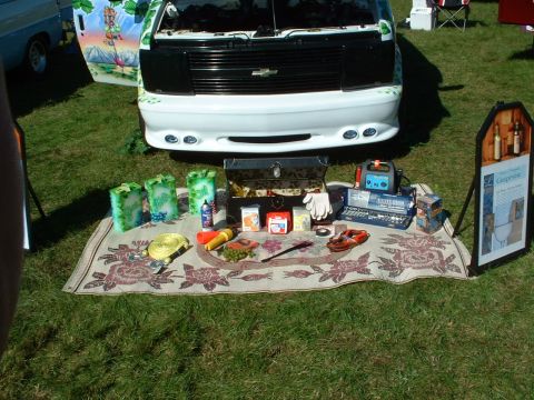 1978 Ford Mustang II - A van is parked on grass with a display of tools and items laid out on a rug in front of it.