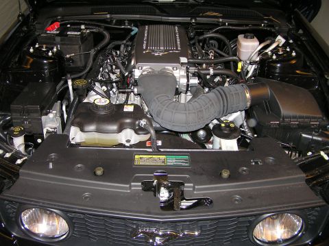 2007 Ford Mustang - The engine bay of a 2007 Ford Mustang, a prominent supercharger and clean engine components.