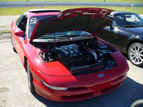 1991 Ford Probe - The front of a red 1991 Ford Probe is shown with its hood open, revealing the engine compartment.