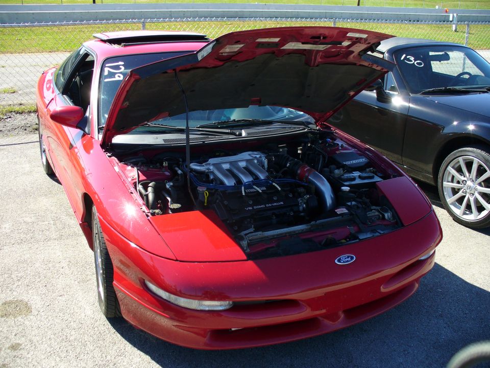 Red 1991 Ford Probe with hood open, showing the engine. Another car is parked next to it