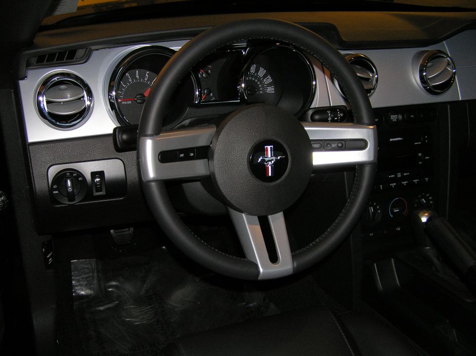 Ford Mustang interior with pony-emblem steering wheel, gauges, and center console