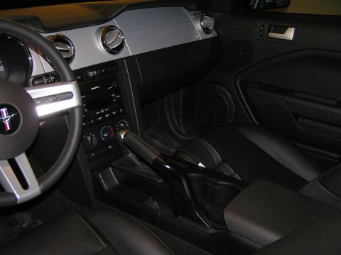 2007 Ford Mustang - The interior of a 2007 Ford Mustang features a black leather interior with silver accents on the dashboard and steering wheel.
