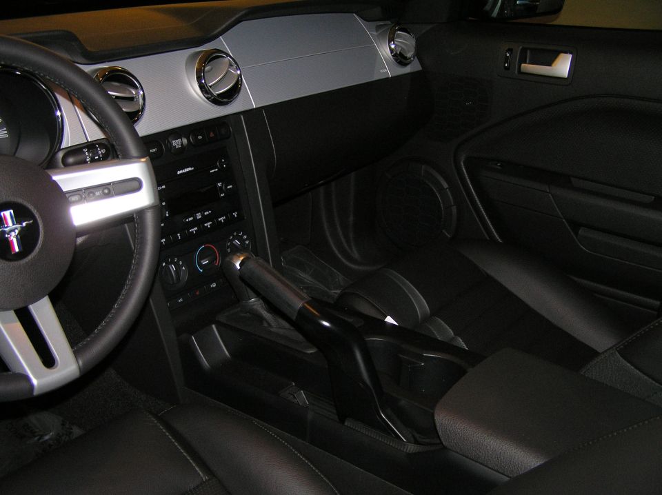 Ford Mustang interior with black seats, silver dash trim, center console and pony steering wheel