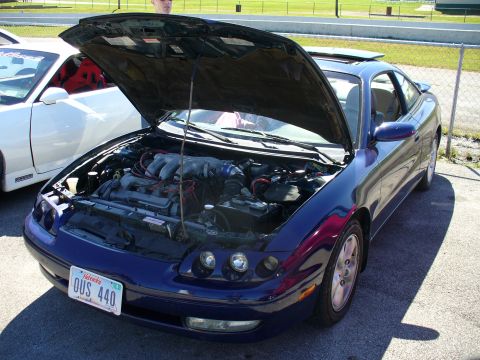 1991 Ford Probe - This 1991 Ford Probe is parked next to a white car, with its hood open to reveal the engine.