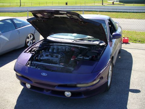 1991 Ford Probe - Front view of a purple 1991 Ford Probe with its hood open, parked next to another vehicle.