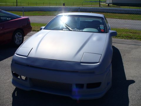 1991 Ford Probe - This 1991 Ford Probe features pop-up headlights and a custom body kit, seen parked next to another vehicle.