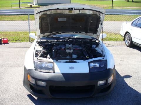1991 Ford Probe - Front view of a Nissan 300ZX with its hood open, parked next to another vehicle.
