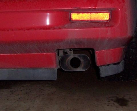 1988 Pontiac Fiero - Rear view of a 1988 Pontiac Fiero, showing the bumper, reflector, and exhaust.