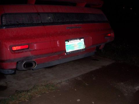 1988 Pontiac Fiero - The rear of a red Pontiac Fiero is shown at night, with a license plate visible.