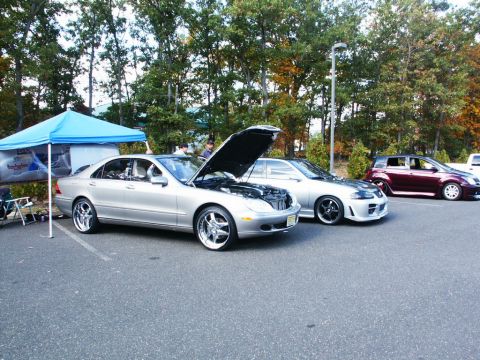 2001 Mercury Grand Marquis - A silver sedan with its hood open and custom wheels is parked at an outdoor event alongside other vehicles.